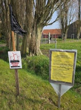 A sign on a pole next to a tree

AI-generated content may be incorrect.